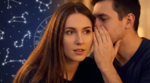Un uomo sussurra all’orecchio di una donna, con costellazioni e ruota zodiacale sullo sfondo